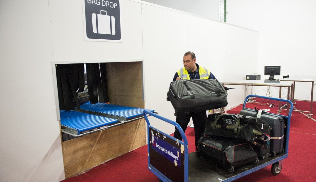 An airport worker handels luggage at the new temporary check-in site at Brussels Airport in Zaventem, Monday 04 April 2016. Since yesterday the airport has partially restarted. In the morning of Tuesday 22nd of March two bombs exploded in the departure hall of Brussels Airport and another one in the Maelbeek - Maalbeek subway station, which made around 35 deadly victims, not including the suicide bombers, and 340 injured people in total. ISIL (Islamic State of Iraq and the Levant - Daesh - ISIS) claimed responsibility for these attacks. BELGA PHOTO LAURIE DIEFFEMBACQ