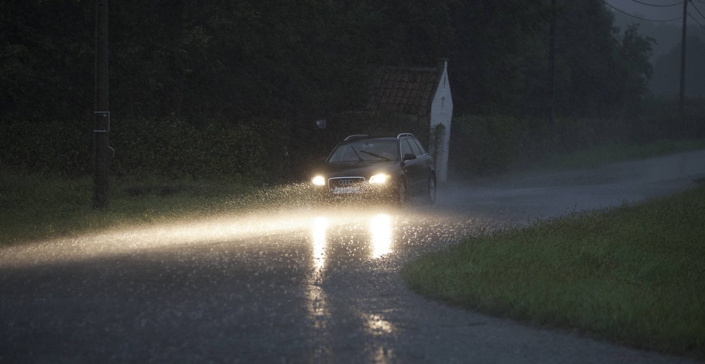 20150813 - KRUISHOUTEM, BELGIUM: Illustration picture shows a car driving with its lights under heavy rain falls on a small road on Thursday 13 August 2015, in Kruishoutem. After a very hot day, storms were announced all over Belgium. BELGA PHOTO NICOLAS MAETERLINCK