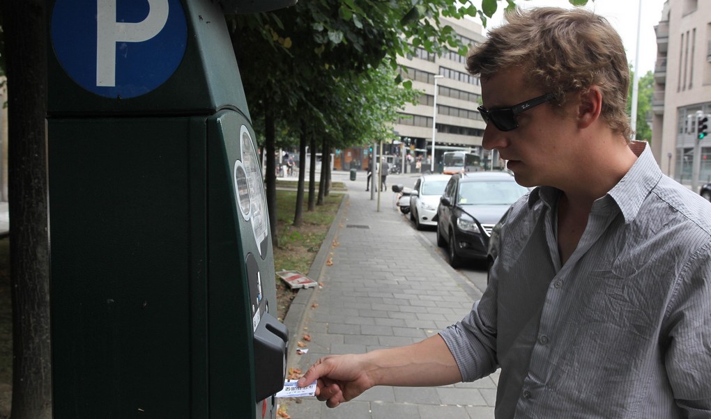 20110712 - BRUSSELS, BELGIUM: Illustration picture shows a man operating a Brussels parking meter, Tuesday 12 July 2011. During the Flemish holiday on July 11th, people were able to park for free due to a mistake in the machine programming. Both the Flemish holiday and the  holiday of the french-speaking community on September 27th are not supposed to be programmed as official holidays. BELGA PHOTO JULIEN WARNAND
